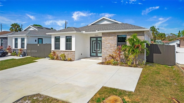 view of front of property featuring french doors and a front lawn