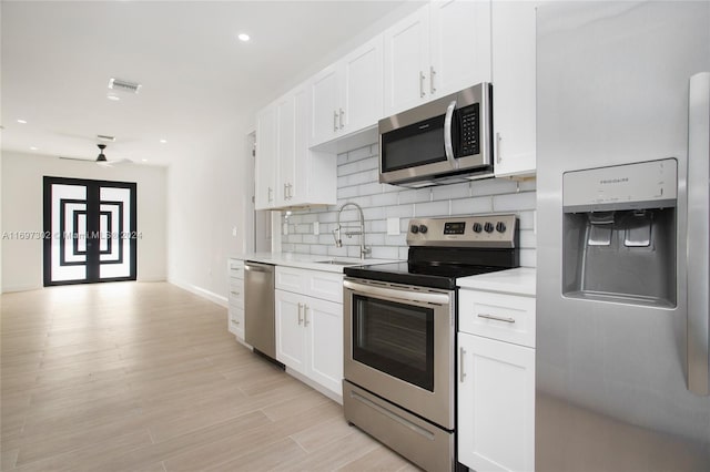 kitchen with white cabinetry, sink, ceiling fan, appliances with stainless steel finishes, and light wood-type flooring