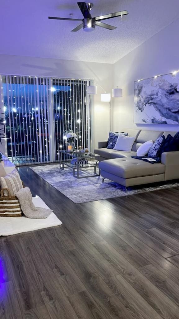 living room featuring hardwood / wood-style floors, a textured ceiling, and ceiling fan