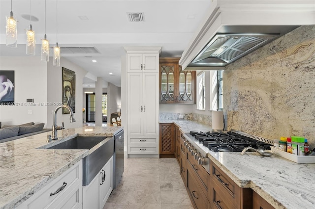 kitchen featuring pendant lighting, sink, appliances with stainless steel finishes, light stone counters, and white cabinets