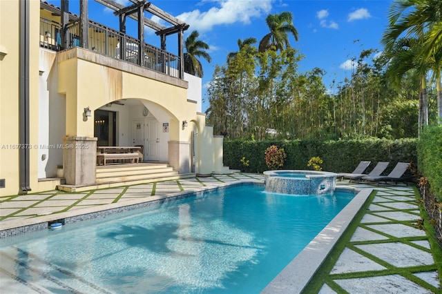 view of swimming pool featuring an in ground hot tub, pool water feature, and a patio