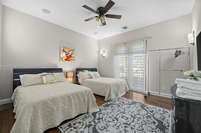 bedroom with dark hardwood / wood-style flooring and ceiling fan