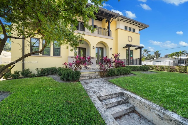 view of front of home with a front lawn and a balcony