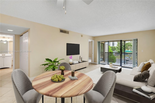 tiled living room featuring ceiling fan and a textured ceiling