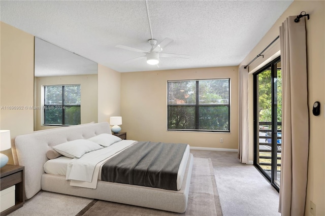 carpeted bedroom with ceiling fan, a textured ceiling, and access to outside