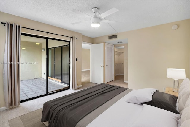 bedroom featuring light carpet, access to outside, ceiling fan, a textured ceiling, and a closet