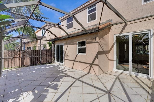 view of patio featuring glass enclosure