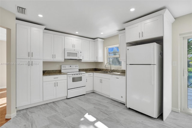 kitchen featuring a healthy amount of sunlight, white appliances, and white cabinetry