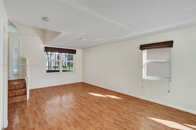 empty room featuring wood-type flooring and a textured ceiling