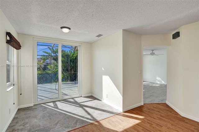 entryway with ceiling fan, wood-type flooring, and a textured ceiling