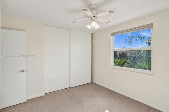 carpeted spare room featuring ceiling fan