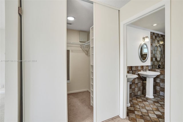 bathroom with ornamental molding and tile walls