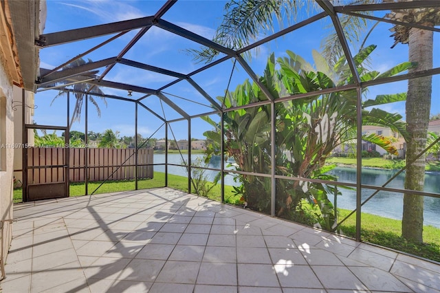 view of patio / terrace with glass enclosure and a water view