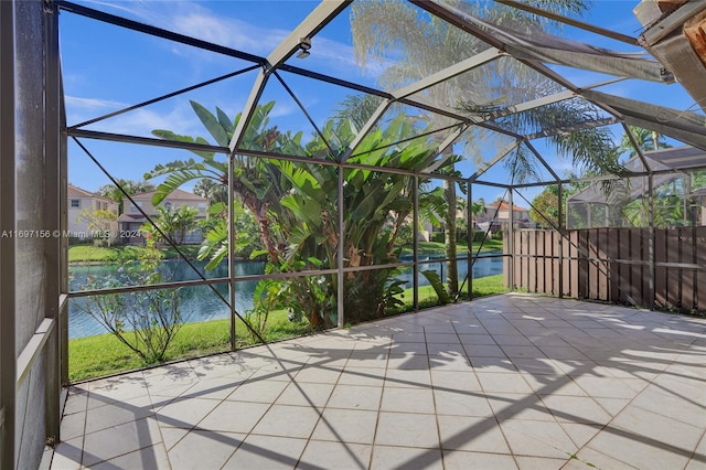 view of patio / terrace featuring glass enclosure and a water view