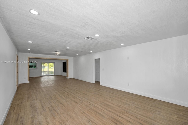 unfurnished living room with hardwood / wood-style flooring and a textured ceiling