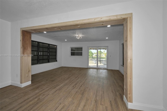 unfurnished room with a textured ceiling and dark wood-type flooring