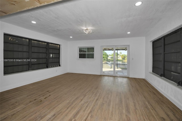 unfurnished living room featuring hardwood / wood-style floors and a textured ceiling