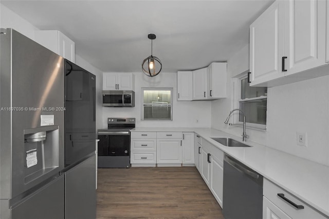 kitchen featuring pendant lighting, sink, white cabinets, and stainless steel appliances