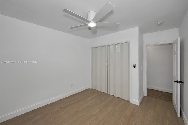 unfurnished bedroom featuring ceiling fan, a closet, and light wood-type flooring