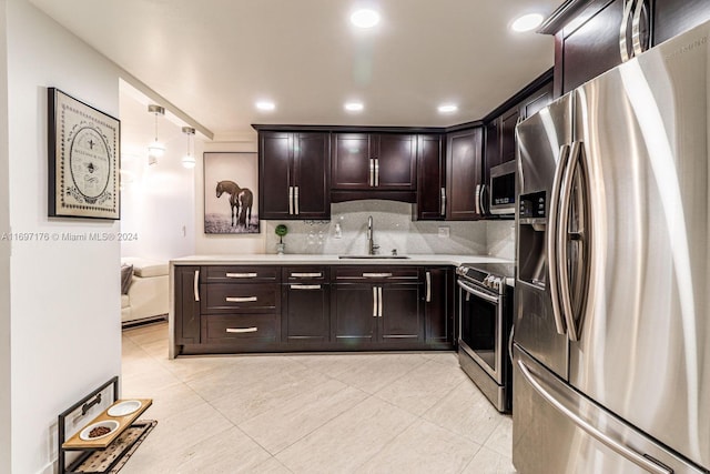 kitchen with sink, hanging light fixtures, stainless steel appliances, tasteful backsplash, and dark brown cabinets