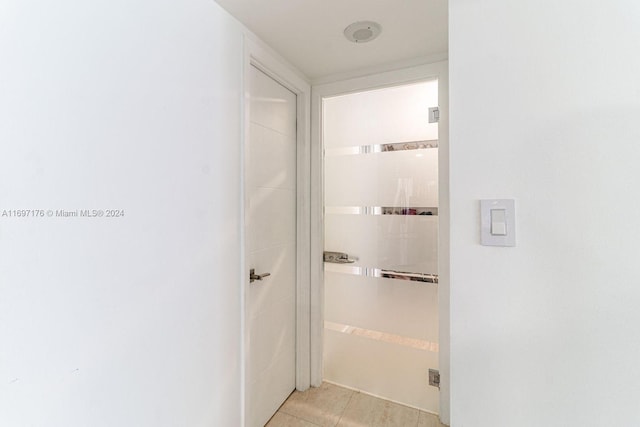 hall with light tile patterned floors