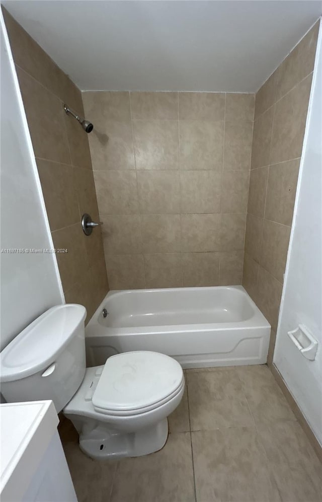 full bathroom with tile patterned flooring, vanity, tiled shower / bath combo, and toilet