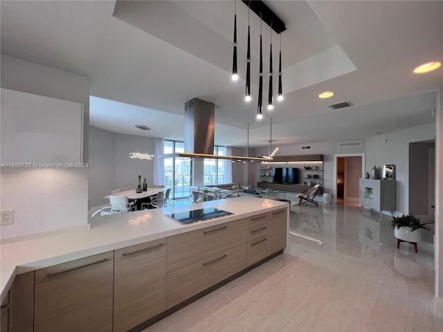 kitchen with black electric stovetop and hanging light fixtures