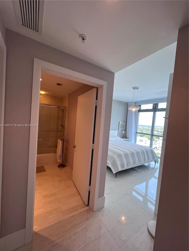 bedroom featuring light hardwood / wood-style flooring and ensuite bath