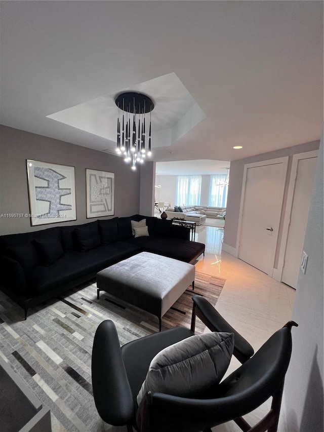 living room with a raised ceiling and an inviting chandelier