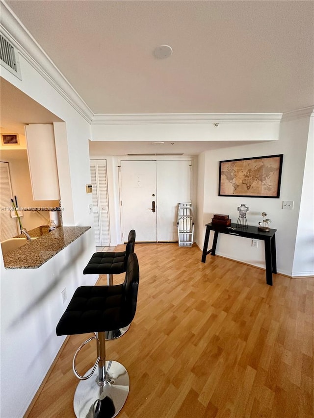 interior space featuring light wood-type flooring and crown molding