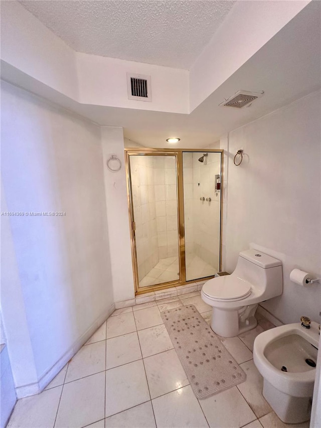 bathroom with tile patterned floors, toilet, a shower with door, and a textured ceiling