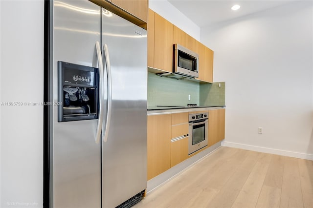 kitchen featuring decorative backsplash, light wood-type flooring, and appliances with stainless steel finishes