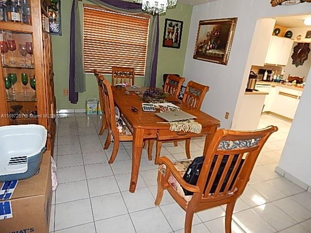 tiled dining space with an inviting chandelier