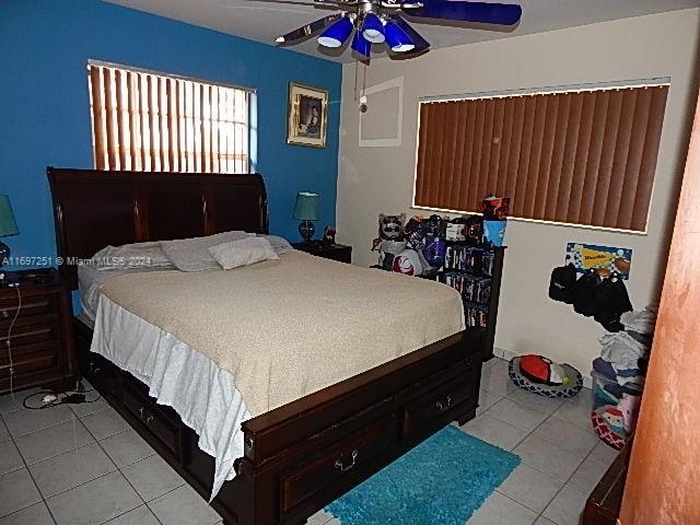 bedroom with ceiling fan and light tile patterned floors