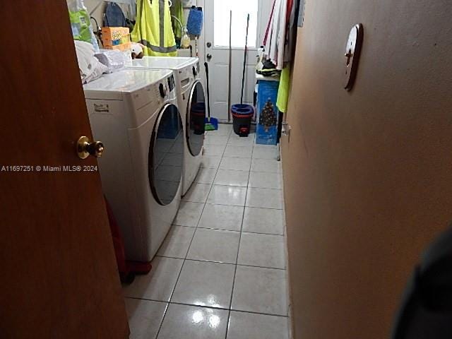 laundry room with light tile patterned floors and washing machine and dryer