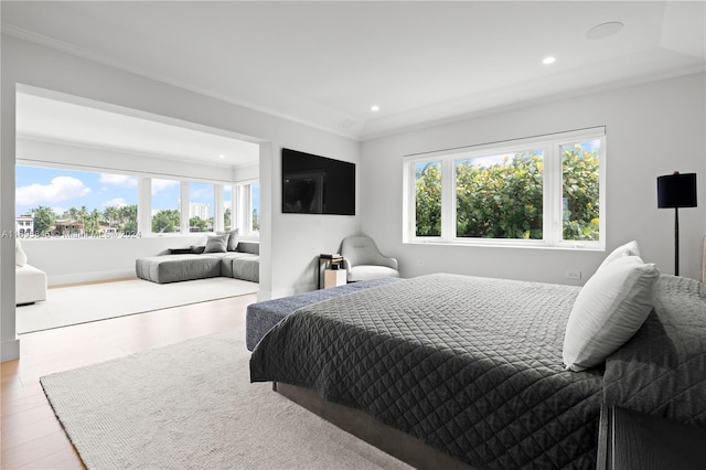 bedroom with ornamental molding, light hardwood / wood-style flooring, and multiple windows