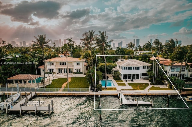 rear view of house featuring a yard, a balcony, a water view, and a patio