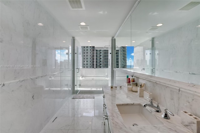 bathroom featuring a shower with door and vanity