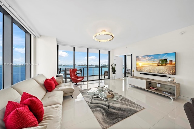 tiled living room featuring floor to ceiling windows, plenty of natural light, and a water view