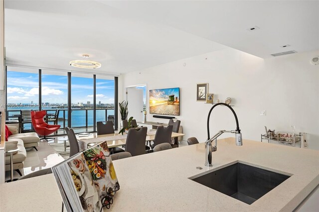788 NE 23rd St Unit 2102, Miami, FL 33137 - kitchen with a sink, floor to ceiling windows, open floor plan, and light stone counters