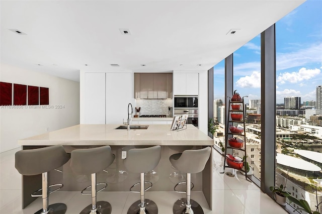788 NE 23rd St Unit 2102, Miami, FL 33137 - kitchen featuring a sink, modern cabinets, a kitchen bar, oven, and tasteful backsplash