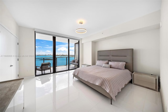 tiled bedroom with access to outside, expansive windows, and a water view