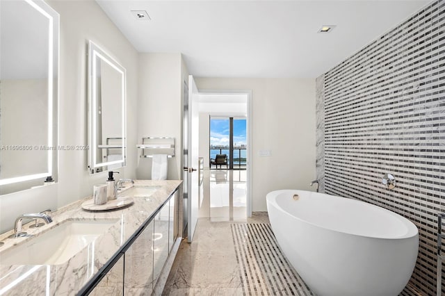 bathroom with a bathtub, tile walls, and vanity