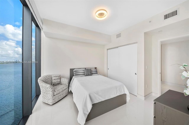 bedroom featuring a water view and a closet