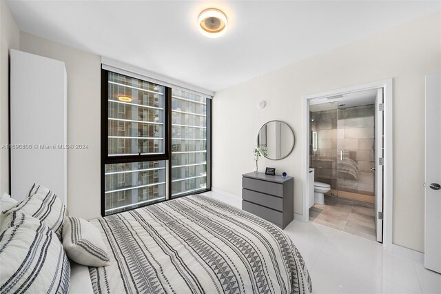 788 NE 23rd St Unit 2102, Miami, FL 33137 - tiled bedroom featuring baseboards and connected bathroom