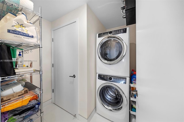 laundry room with light tile patterned floors and stacked washer and clothes dryer