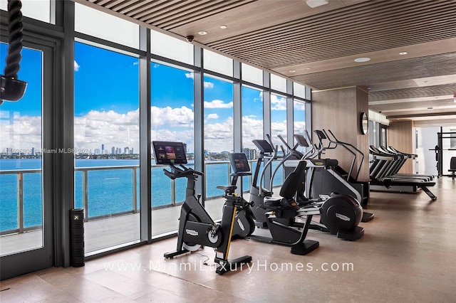 gym featuring floor to ceiling windows, a water view, and wooden ceiling