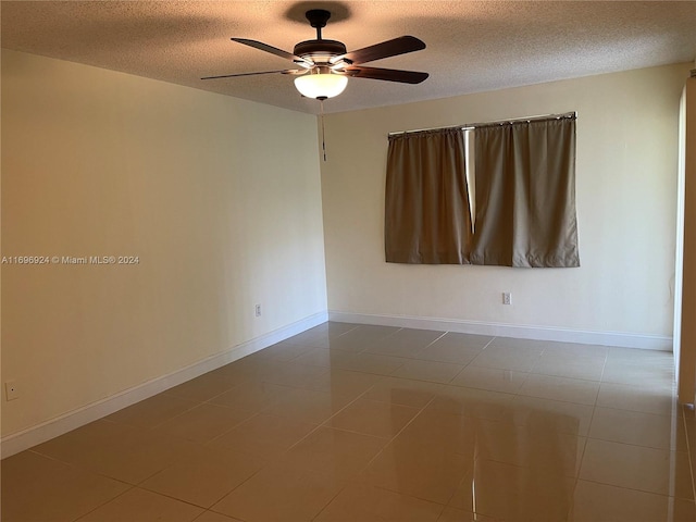 unfurnished room featuring ceiling fan, tile patterned flooring, and a textured ceiling