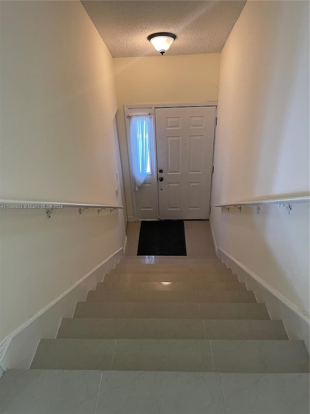 stairway with a textured ceiling