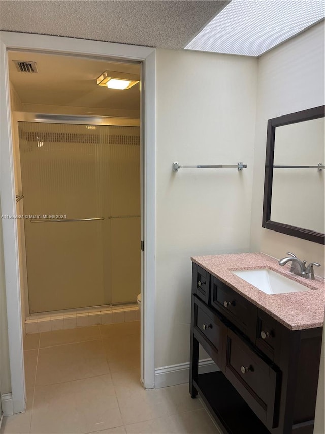 bathroom featuring tile patterned floors, vanity, toilet, and walk in shower